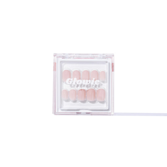 A clear box showcasing a set of pink acrylic nails with sophisticated French tips is displayed. The box features the brand name "Glowie By Her" printed on it, offering salon-quality nails at home and highlighting the product name "Christi.