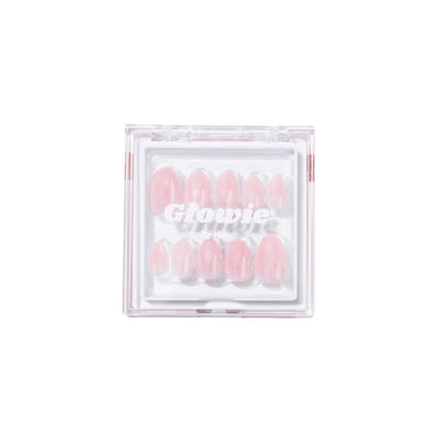 A transparent plastic case labeled "Glowie By Her" contains a set of pink, salon-quality Fairydust Press-On Nails arranged in rows. Each glossy nail varies in size to fit different fingers and features an iridescent chrome finish for an extra touch of glamour.