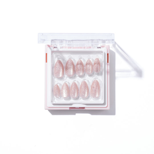 A box of Glowie By Her's "Make a Wish," featuring pink glittery press-on nails with a stunning cat-eye effect, arranged inside a transparent and white container with a lid, displayed against a white background.
