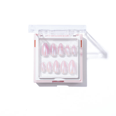 A plastic container with a transparent lid is shown, containing a set of 777 Press-On Nails by Glowie By Her. The salon-quality, limited edition artificial nails are arranged in rows and feature a glossy, iridescent finish with a pinkish hue. The container is placed on a white background.